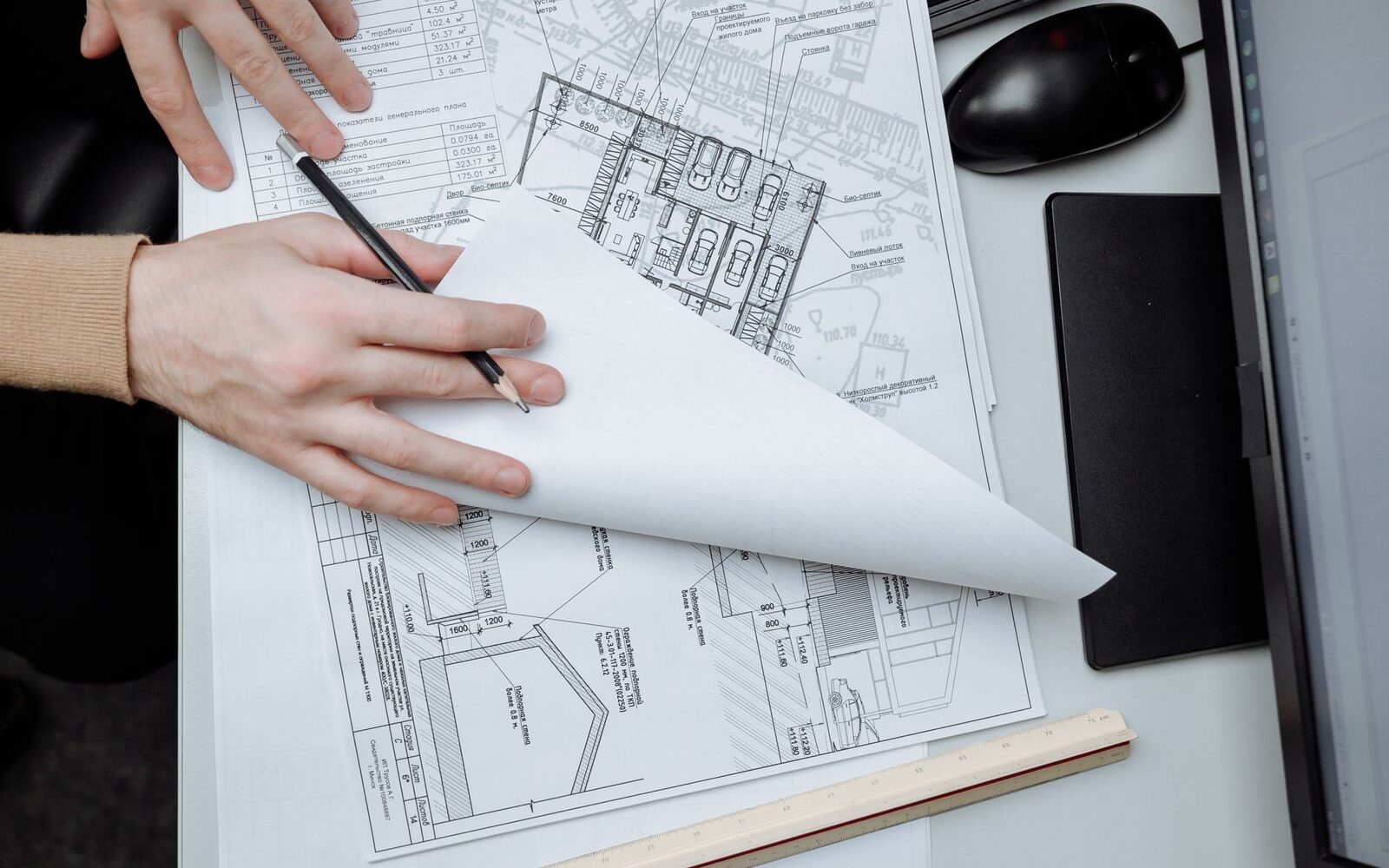 An architect's desk with a sketch, pencils and a rule