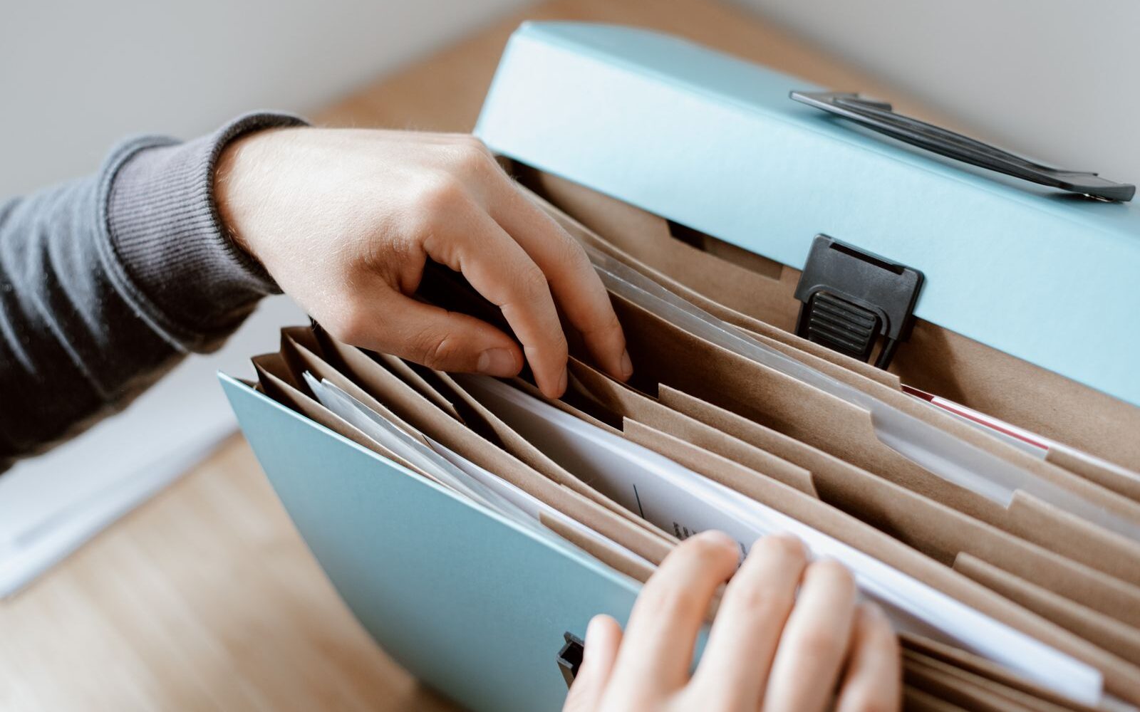 Hands going through a file folder of documents
