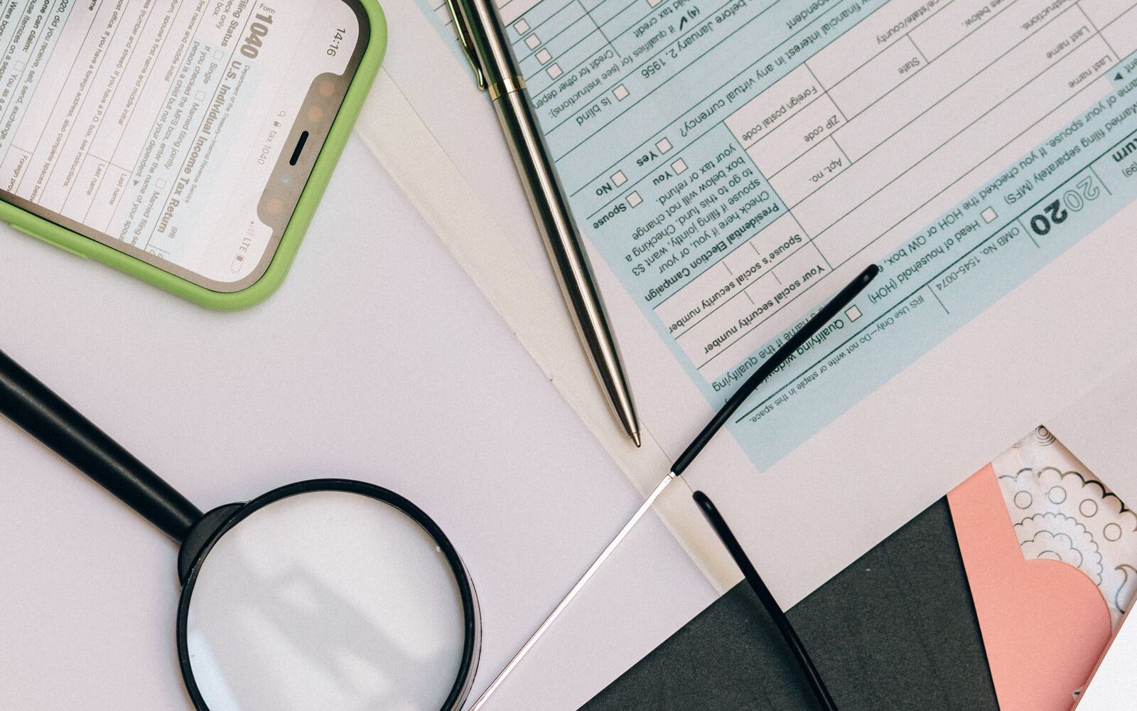 A magnifying glass over paperwork on a desk