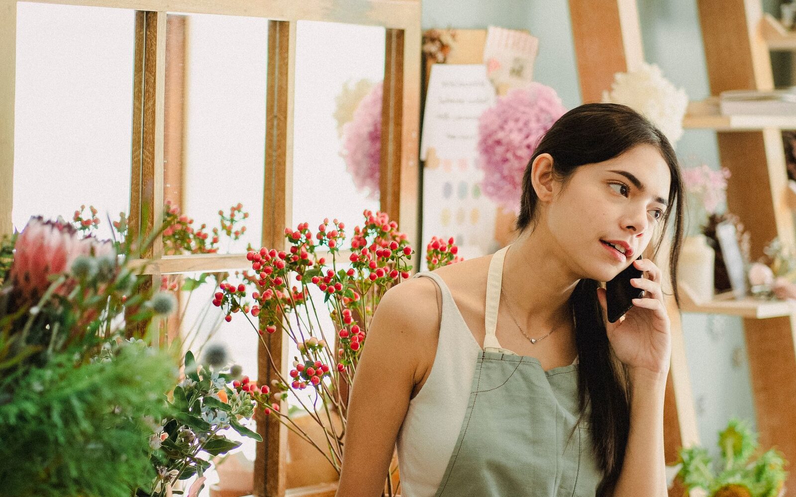 A florist taking a call in her own shop