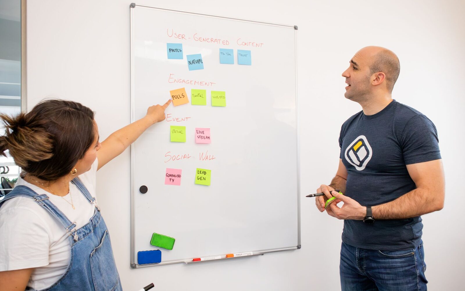 Two people mapping work out with sticky notes on a whiteboard